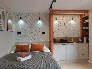 a bedroom with a bed next to a kitchen at Apartamenty Janasa 13 in Chorzów