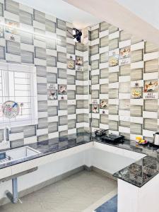 a kitchen with a checkerboard patterned wall at AAG Pride serviced apartments in Pollāchi +12 photos