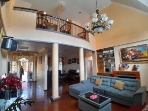 a living room with a blue couch and a staircase at Villa Dinar Mountain Estate in Lembang