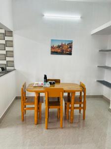 a dining room with a wooden table and chairs at AAG Pride serviced apartments in Pollāchi