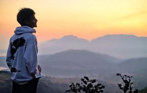 a man standing on top of a mountain looking at the mountains at HOTEL Shiv Sai in Shirdi