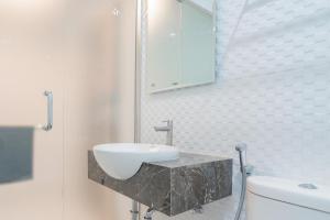 a bathroom with a sink and a toilet at RedDoorz Plus near Siloam Hospital Balikpapan in Balikpapan