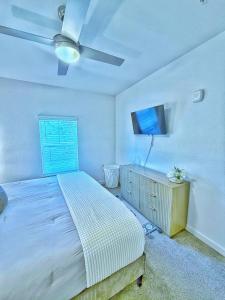 a bedroom with a bed and a flat screen tv at Beachline Oasis in Jacksonville