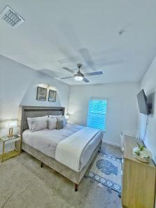 a bedroom with a bed and a ceiling fan at Beachline Oasis in Jacksonville +32 photos