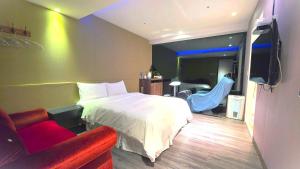 a bedroom with a bed and a couch and a tv at Colors Infinity Inn in Taipei