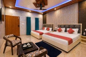 a bedroom with two beds and a chair and a table at Aqua Tree Resort in Rishīkesh +37 photos