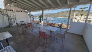 a restaurant with tables and chairs and a view of the water at Zoe Pension in Ermioni