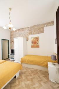 a bedroom with two beds and a brick wall at Apartment Poluotok in Zadar