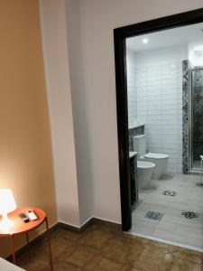 ein Badezimmer mit Toilette, Tisch und Spiegel in der Unterkunft Armoniasdecanna in Monastir