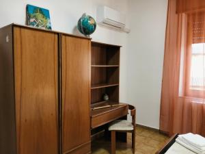 ein Holzschrank mit einem Schreibtisch in einem Zimmer in der Unterkunft Armoniasdecanna in Monastir