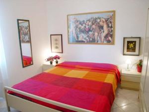 Schlafzimmer mit farbenfrohem Bett und Wandgemälde in der Unterkunft Riviera Appartament in Grado