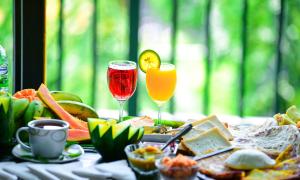 a table topped with two glasses of wine and food at Infinite cabana in Ella