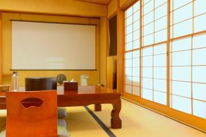 a meeting room with a table and a projection screen at 熱海の隠れ里 in Atami +132 photos