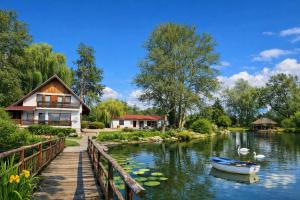 a house and a boat on a river at Вили Янкови in Dobri Dyal +22 photos