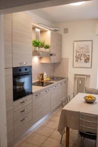 a kitchen with wooden cabinets and a dining table at VENICE Sweet Home - your home in a beautiful neighborhood of the City of Venice in Favaro Veneto