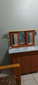 a wooden cabinet with three windows in a room at Malan's Siësta 2 in Kimberley