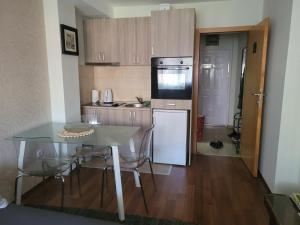 a small kitchen with a table and a refrigerator at Stan na dan Loznica in Loznica