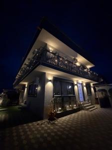 a house with a balcony on top of it at night at Casa Belle in Năvodari