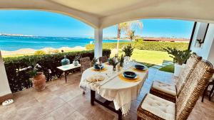 a table on a patio with a view of the ocean at Villa Incanto on the Sea in Syracuse