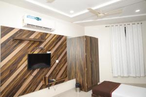 a bedroom with a wooden wall with a tv at Hotel SR Siddhivinayak Mathura in Mathura