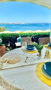 a table with blue and yellow plates on the beach at Villa Incanto on the Sea in Syracuse