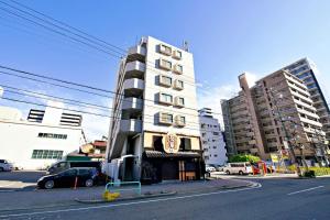a tall white building with cars parked in front of it at Crest YS chiyoda 4B in Aoichō