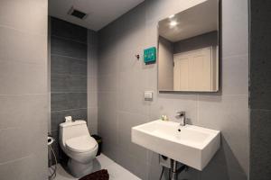 a bathroom with a toilet and a sink and a mirror at Jomtien Beach Sleep Inn - Steps from Beach & Market in Jomtien Beach +54 photos