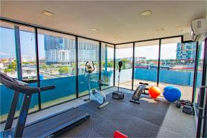 an apartment gym with a view of the city at Jomtien Beach Sleep Inn - Steps from Beach & Market in Jomtien Beach
