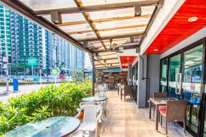 a patio of a restaurant with tables and chairs at Jomtien Beach Sleep Inn - Steps from Beach & Market in Jomtien Beach
