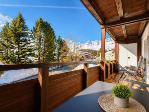 a balcony with a table and a view of the mountains at Chalet Höfi - Ski-in Ski out at Hörnlilift by Arosa Stay in Arosa