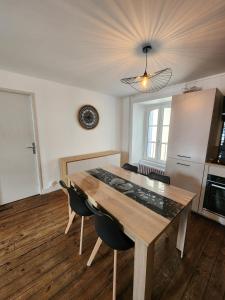 a dining room with a wooden table and chairs at Joli appartement T3 in Allassac