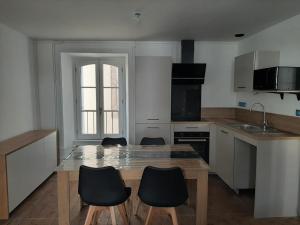 a kitchen with a table and chairs in a kitchen at Joli appartement T3 in Allassac +2 photos