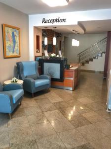 a waiting room with chairs and a tv and stairs at Hotel Anita in Budva