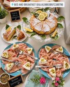 a table topped with plates of food with meat and cheese at B&B Giulia in Taormina