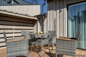a patio with a table and chairs on a deck at Sunset House in Palanga