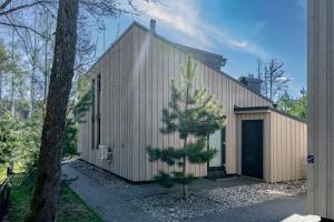 a house with a pine tree in front of it at Sunset House in Palanga +38 photos