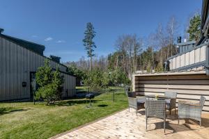 a patio with chairs and a table in a yard at Sunset House in Palanga