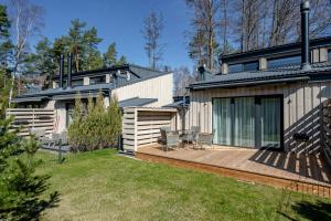 a house with a wooden deck next to a yard at Sunset House in Palanga