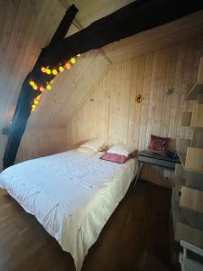 ein Schlafzimmer mit einem Bett in einer Holzwand in der Unterkunft Bugatti Chill in Moncé-en-Belin