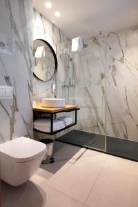 ein Badezimmer mit Toilette und Waschbecken in der Unterkunft Hotel Marfany in Andorra la Vella + 98 Fotos