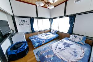 a room with two beds and a flat screen tv at Oasis Wadaura in Minamiboso