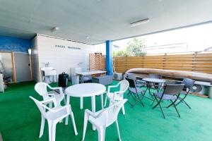 a room with white tables and chairs and a pool at Oasis Wadaura in Minamiboso