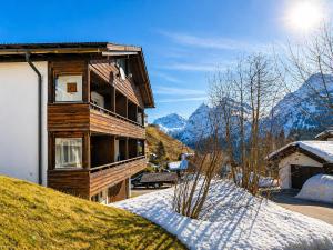 a house with snow on the ground next to a building at Chalet Höfi - Ski-in Ski out at Hörnlilift by Arosa Stay in Arosa