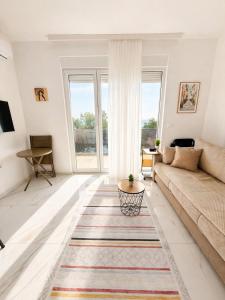 a living room with a couch and a rug at MangaRenga apartments in Šušanj