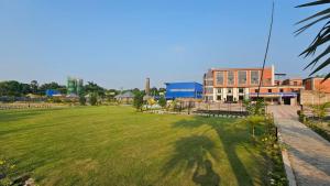 a large field of grass with a building in the background at Balaji Hotel and Resturant in Kolaghat