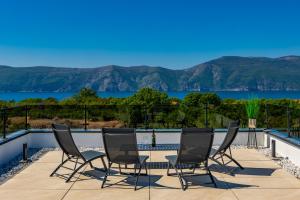 a group of chairs on a balcony with a view of the water at Villa Vela in Brzac