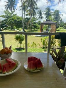 a table with two plates of water melons and a bowl of fruit at Crespina Private House in General Luna