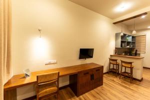 a home office with a wooden desk and a television at Aqualuna Weligama in Weligama