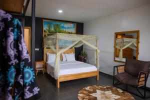 a bedroom with a canopy bed and a chair at Eagle View Lodge - Kigali in Kigali