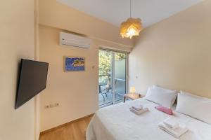 a bedroom with a bed with a flat screen tv at Folitsa happy central home in Rhodes Town